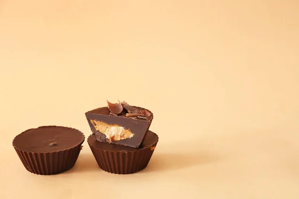 Tasty chocolate peanut butter cups on color background — Stock Photo, Image