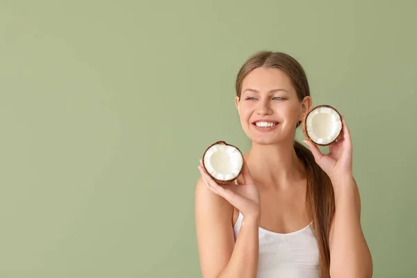 Bella giovane donna con noce di cocco su sfondo di colore — Foto Stock