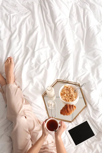 Frau frühstückt lecker im Bett — Stockfoto
