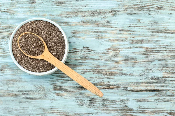 Bowl and spoon with chia seeds on wooden table — Stock Photo, Image