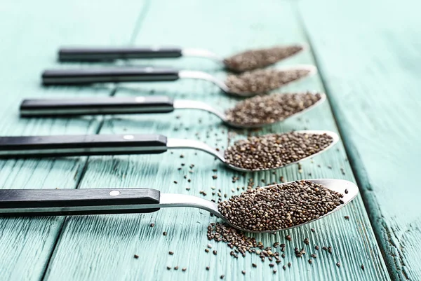 Spoons with chia seeds on wooden table — Stock Photo, Image