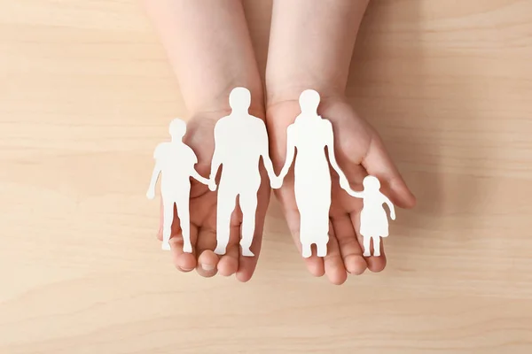 Las manos del niño con la figura de la familia sobre el fondo claro. Concepto de adopción — Foto de Stock