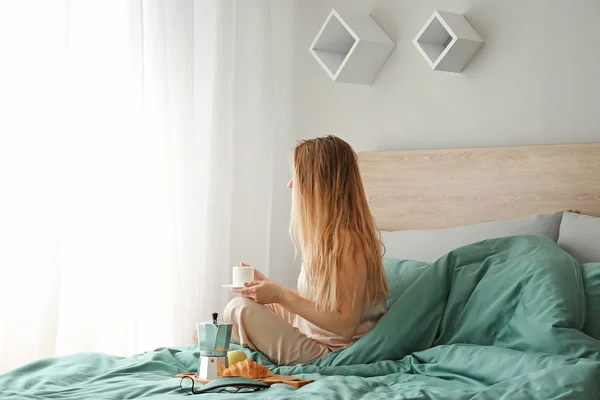 Mujer joven desayunando en la cama — Foto de Stock