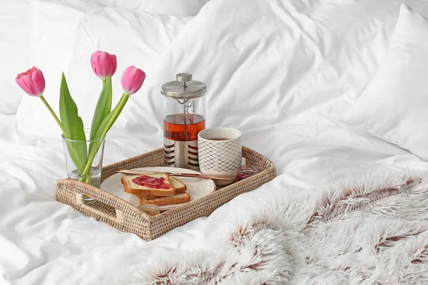 Tray with tasty breakfast on bed — Stock Photo, Image