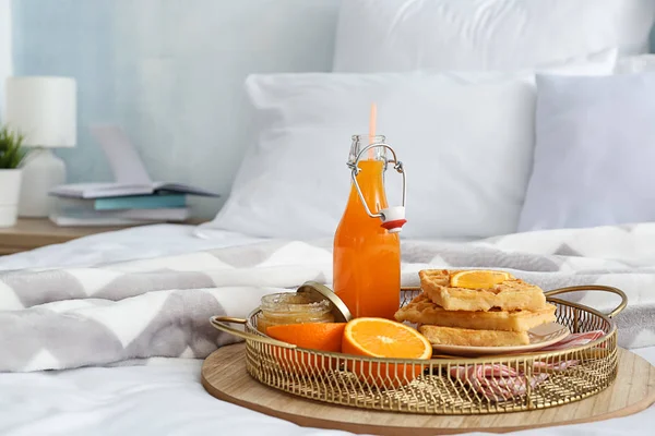 Tray with tasty breakfast on bed — Stock Photo, Image