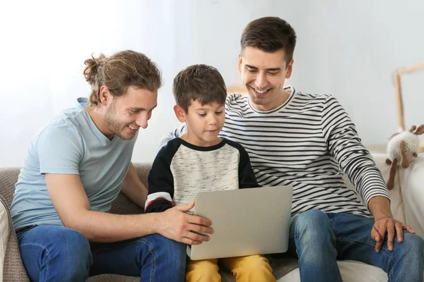 Glückliches homosexuelles Paar und Adoptivkind mit Laptop zu Hause — Stockfoto