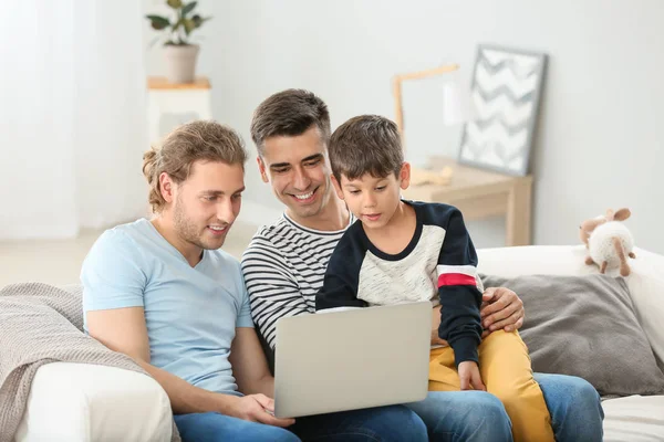 Glückliches homosexuelles Paar und Adoptivkind mit Laptop zu Hause — Stockfoto