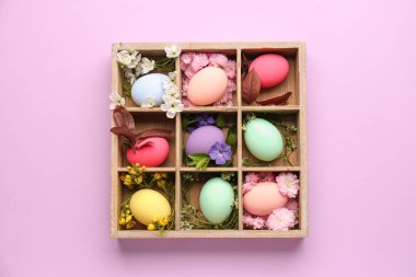 Renkli arka planda güzel Paskalya yumurtaları ile bölünmüş kutu