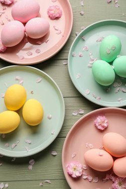 Ahşap arka plan üzerinde güzel Paskalya yumurtaları ile Tabaklar