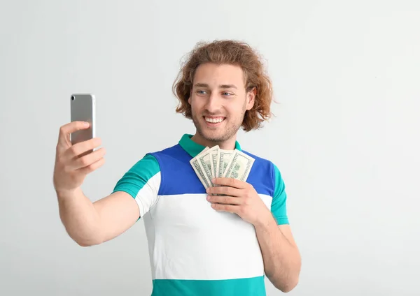 明るい背景に自分撮りを取るドル紙幣を持つ幸せな若者 — ストック写真