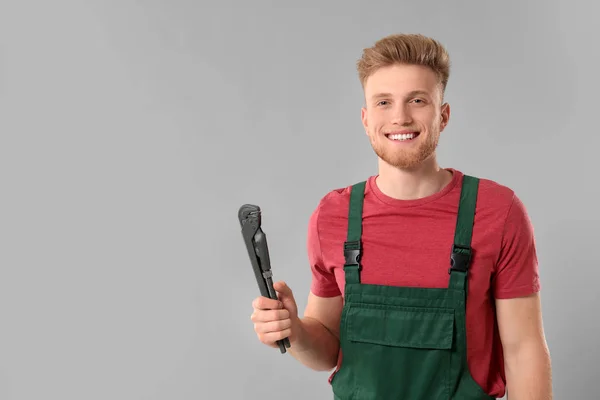 Handsome plumber on grey background — Stock Photo, Image