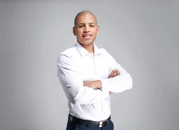 Handsome African-American businessman on grey background — Stock Photo, Image