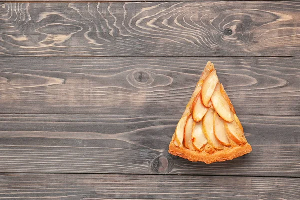 Pedazo de sabroso pastel de manzana sobre fondo de madera — Foto de Stock