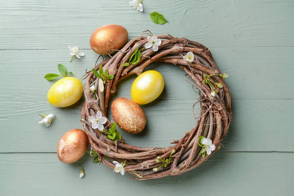 Nest with beautiful Easter eggs on wooden background — Stock Photo, Image