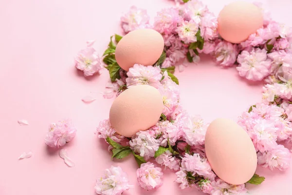 Belos ovos de Páscoa com flores no fundo de cor — Fotografia de Stock