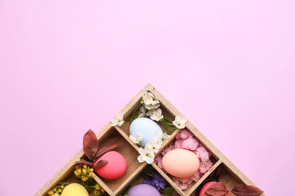 Caja dividida con hermosos huevos de Pascua sobre fondo de color —  Fotos de Stock