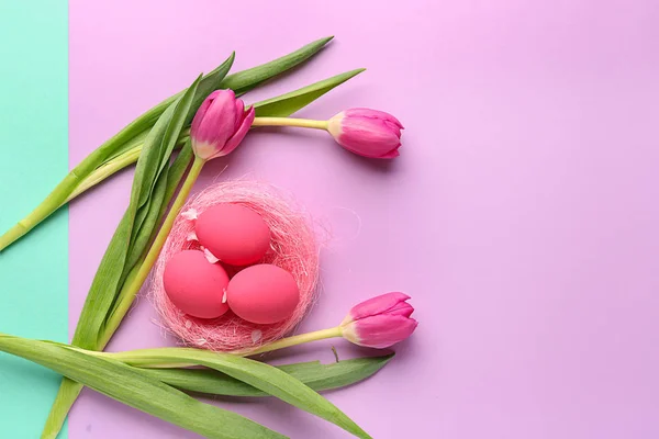 Beautiful Easter eggs with flowers on color background — Stock Photo, Image