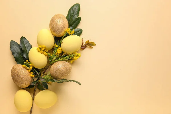 Beaux œufs de Pâques avec des feuilles vertes et des fleurs sur fond de couleur — Photo