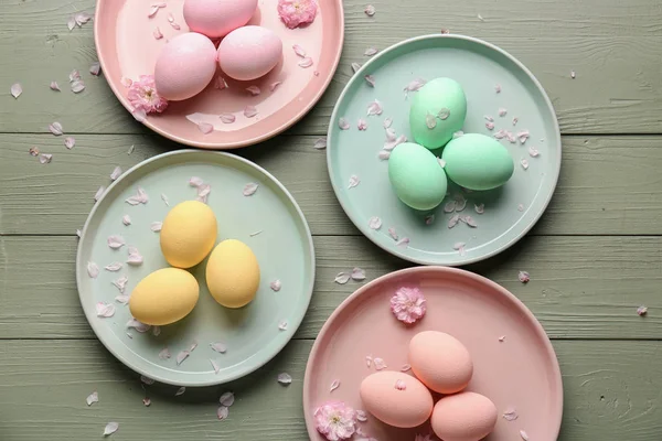 Plates with beautiful Easter eggs on wooden background — Stock Photo, Image