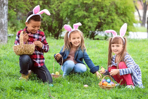 Kisgyerekek összegyűjtése húsvéti tojást Park — Stock Fotó