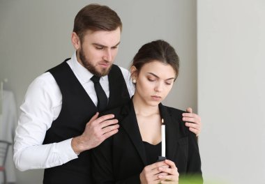 Couple pining after their relative at funeral clipart