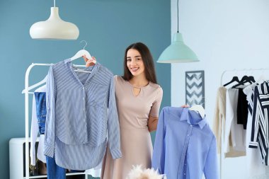Soyunma odasında kıyafet seçen genç kadın