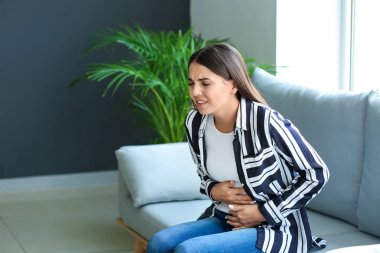 Evde mide ağrısı çeken genç kadın