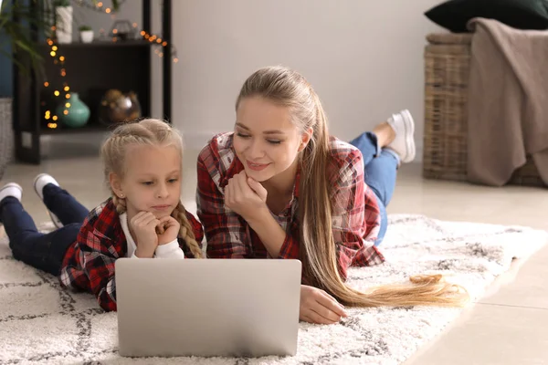 Junge Mutter mit kleiner Tochter schaut Cartoons zu Hause — Stockfoto