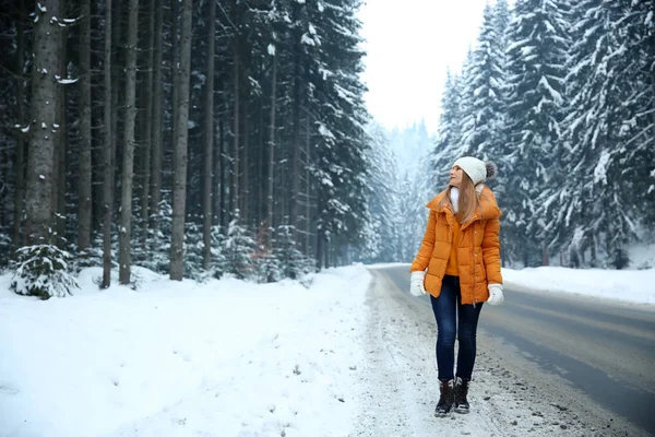 Vacker ung kvinna nära vägen i vinter skog — Stockfoto