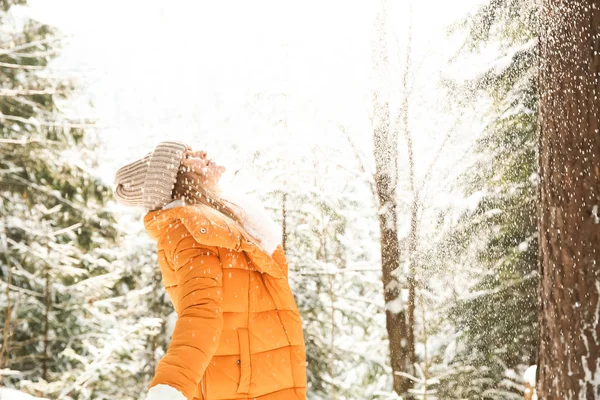 Beautiful woman playing with snow in winter forest — Stock Photo, Image