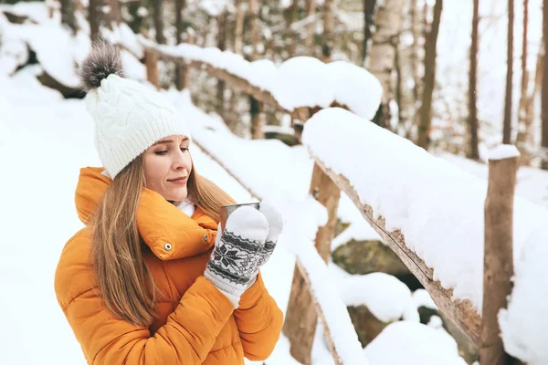 Hermosa mujer con bebida caliente en el bosque de invierno —  Fotos de Stock