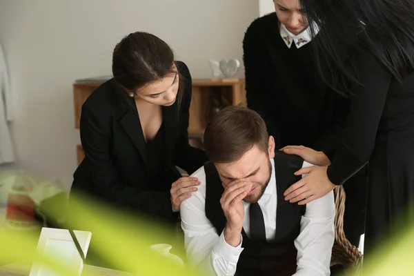 Angehörige beruhigen jungen Witwer bei Beerdigung — Stockfoto