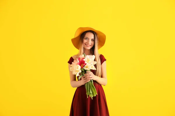 Mladá žena s kyticí krásné tulipány na barvu pozadí — Stock fotografie