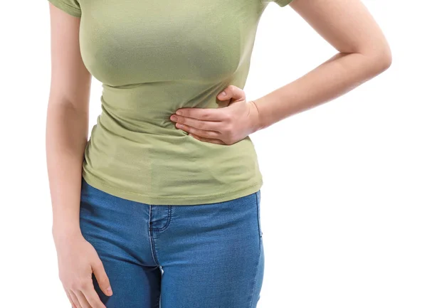 Mladá žena trpící žaludky na bílém pozadí — Stock fotografie