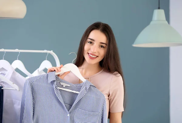 Happy young woman with stylish shirt in dressing room — Stock Photo, Image