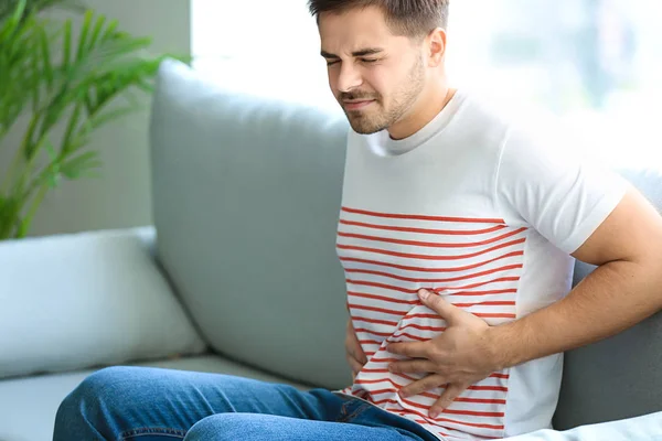 Νεαρός που υποφέρει από στομαχόπονο στο σπίτι — Φωτογραφία Αρχείου