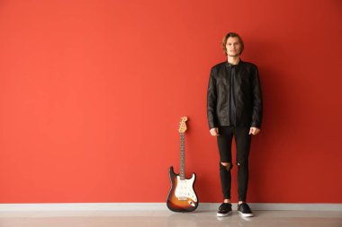 Renkli duvara yakın gitar ile Yakışıklı genç adam