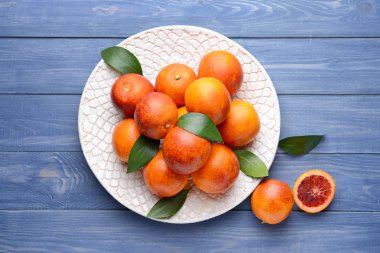 Ahşap masa üzerinde taze kan portakal ile Plaka