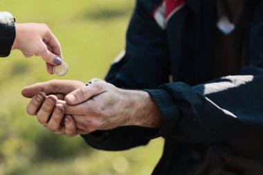 Dışarıdaki zavallı evsiz adama para veren bir kadın.