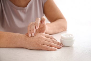 Olgun kadın evde el kremi uygulayarak, kapatmak