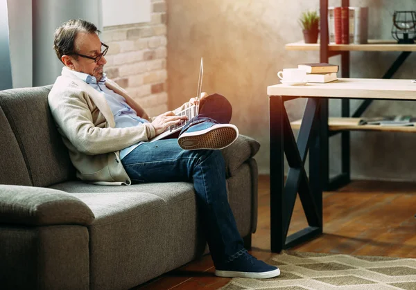 Bello uomo maturo che utilizza il computer portatile a casa — Foto Stock