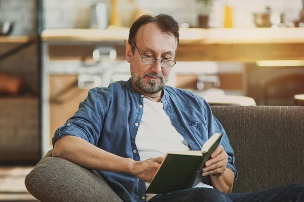 Bello maturo uomo lettura libro a casa — Foto Stock