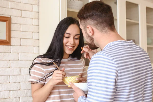 Bonito jovem casal tomando café da manhã na cozinha — Fotografia de Stock