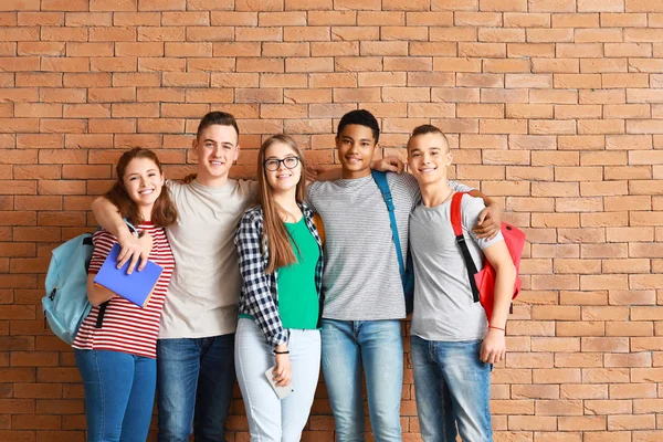 Skupina teenagerů v blízkosti cihlové zdi — Stock fotografie