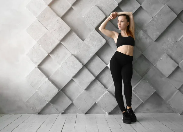 Sportliche Frau gegen graue Wand — Stockfoto