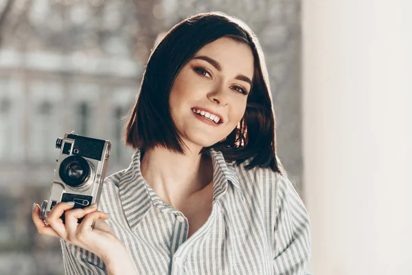 Belle jeune femme avec appareil photo le jour ensoleillé — Photo