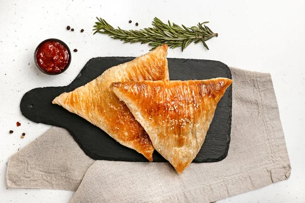 Tavola di ardesia con deliziose samosa e salsa su sfondo chiaro — Foto Stock