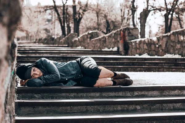Pobre vagabunda tumbada en escaleras al aire libre —  Fotos de Stock