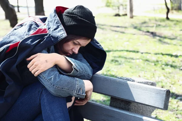 Povera senzatetto seduta sulla panchina all'aperto — Foto Stock