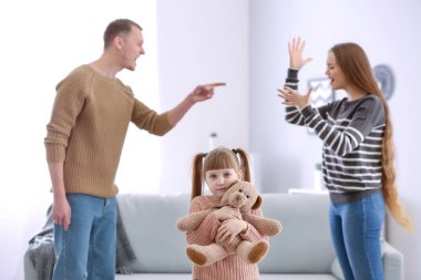 Üzgün küçük kız ve kavgacı ailesi evde.